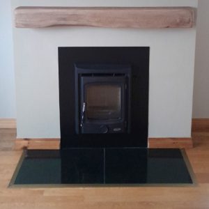 henley Muckross insert stove mounted onto a wall with a steel backing plate and faux mantlepiece