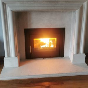 A lighting Henley Eco c550 installed in a white/grey marble fireplace